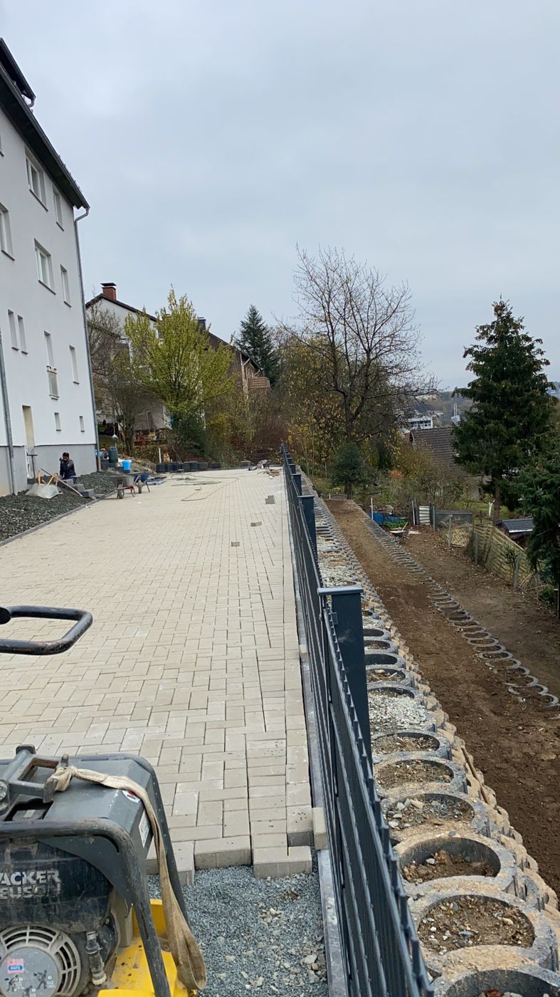 Hofpflaster mit Zaun und Stützmauer
