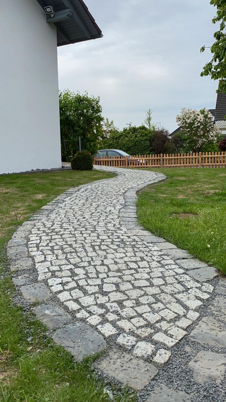 Geschwungener Weg aus Granitpflaster
